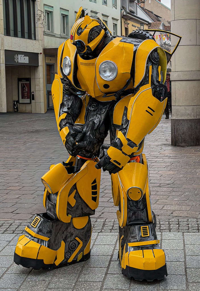 Basel Dreiländereck – Urbanes Bumblebee Cosplay Wandbild in Nahaufnahme | Spektakuläre Urban- und Street-Fotografie aus dem Basler Dreiländereck: Dieses High-End Wandbild zeigt eine detailreiche Nahaufnahme des legendären gelben Transformers Bumblebee. Die haptischen mechanischen Strukturen, die matte Lackierung und die beeindruckende Kulisse machen diese exklusive Cosplay-Fotografie zu einem echten Statement-Piece. Gedruckt in Galeriequalität – ideal für Gaming-Zimmer, Heimkinos und Liebhaber moderner Pop-Kultur auf Acrylglas oder Alu-Dibond. - Realisiert mit Pictrs.com