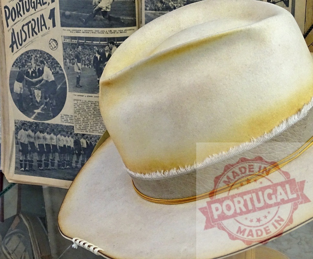 Vintage fedora hat near old sports newspaper | Vintage fedora hat resting on a newspaper with Portugal vs Austria soccer match story - Realized with Pictrs.com