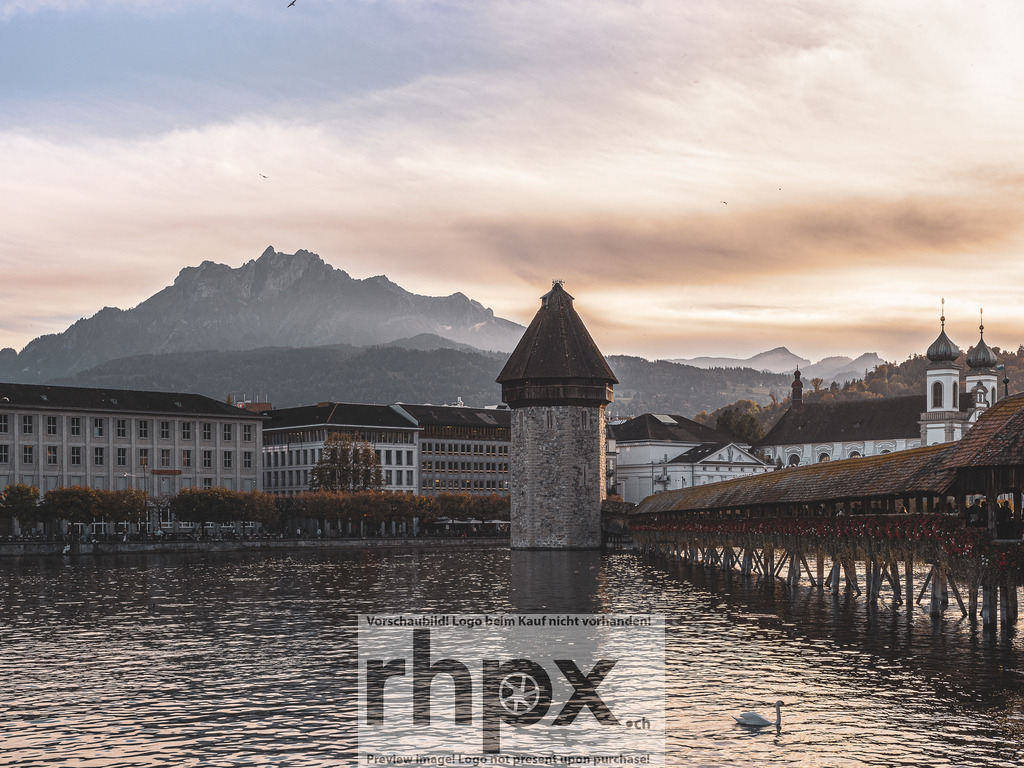 Kapellbrücke und Pilatus im Abendlicht | Geschichte. Licht. Erhabenheit.Das warme Leuchten des Sonnenuntergangs hüllt die historische Kapellbrücke und den Wasserturm in eine tolle Atmosphäre. Im Hintergrund erhebt sich der Pilatus über die Stadt und vollendet dieses klassische Panorama der Zentralschweiz. Ein zeitloser Moment, der Ruhe und die beständige Schönheit Luzerns ausstrahlt.Wähle unter "Produktauswahl" dein Wunschformat: Vom klassischen Wandbild über Puzzle &amp; Tassen bis zum digitalen Download (z.B. als Handy-Hintergrund). - Realisiert mit Pictrs.com