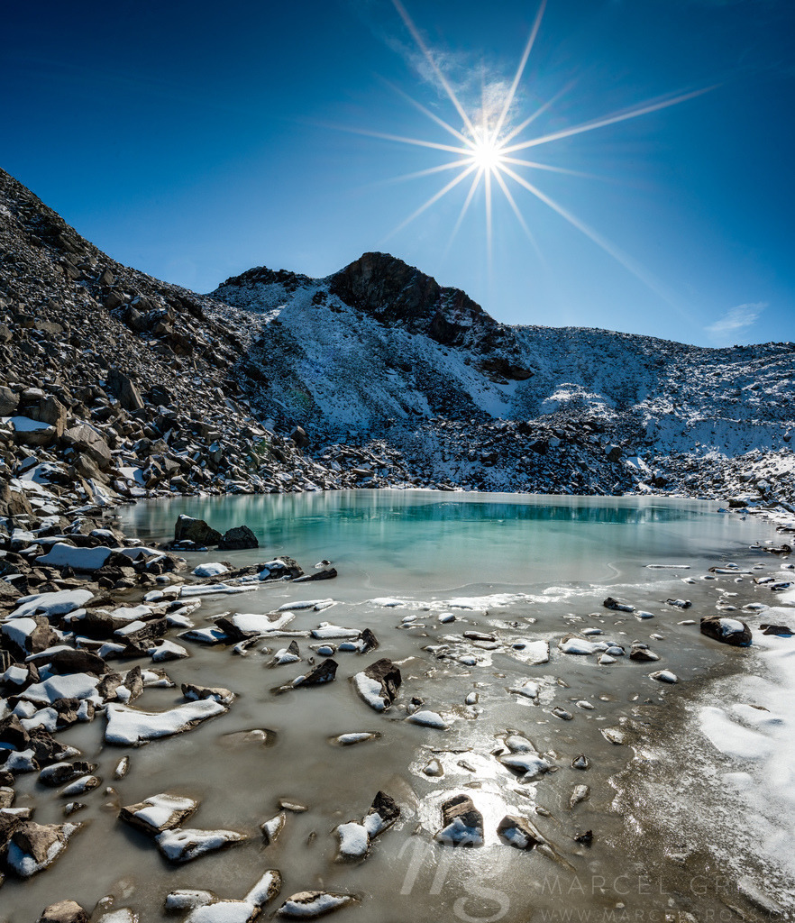 Türkisfarbener See auf der Macun Seenplatte im ersten Schnee im Herbst | Die ideale Geschenkidee für Naturliebhaber. Naturbilder von Marcel Gross Photography für ihr Zuhause in den verschiedensten Formaten und Materialien. - Realisiert mit Pictrs.com