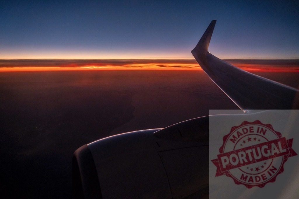 Airplane wing flying during a vibrant sunset light | Airplane wing and engine with orange sunset light over the horizon and clouds - Realisiert mit Pictrs.com