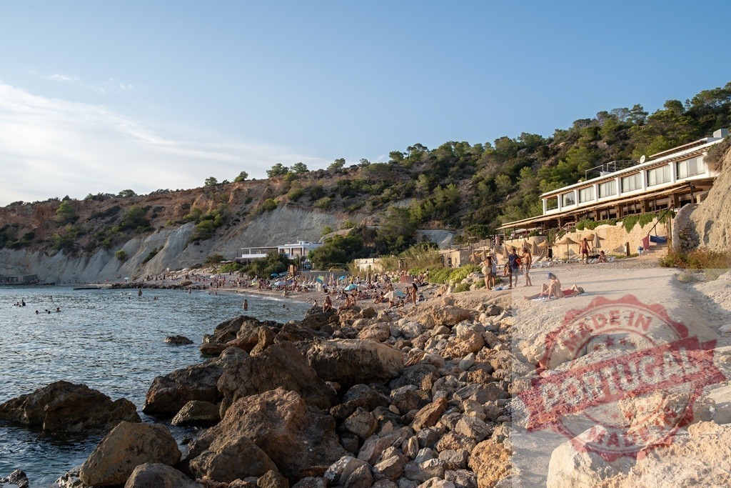 Ibiza beach resort bar and people enjoying summer vacation | People relaxing and swimming on a rocky beach with a cliffside resort bar - Realized with Pictrs.com