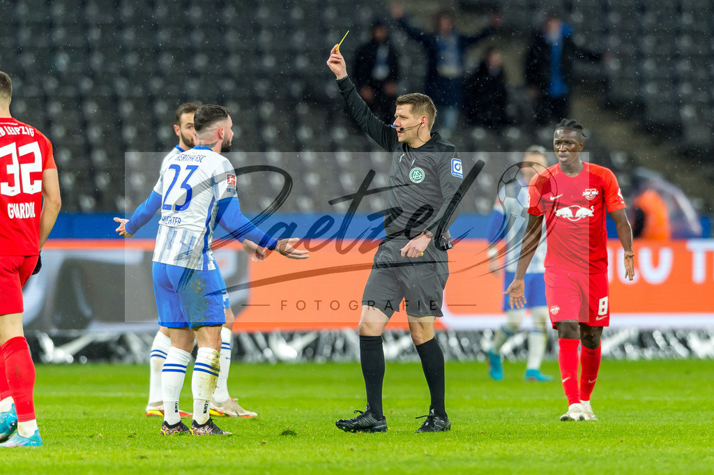 BSCRBL20220220_044 | Fussball, Herren: Schiedsrichter Patrick Ittrich zeigt Marco Richter (Hertha BSC) die gelbe Karte bei dem Spiel der 1. Bundesliga zwischen Hertha BSC und RB Leipzig im Olypiastadion am 20.02.2022 in Berlin, Deutschland.DFB / DFL REGULATIONS PROHIBIT ANY USE OF PHOTOGRAPHS AS IMAGE SEQUENCES AND/OR QUASI-VIDEO. - Realisiert mit Pictrs.com