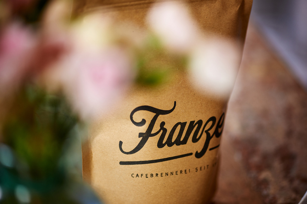 Cafebrennerei Franze | Wien, Austria - July 24, 2019: Cafebrennerei Franze am Kutschkermarkt, Packung mit Kaffee auf dem Tisch. - Realisiert mit Pictrs.com