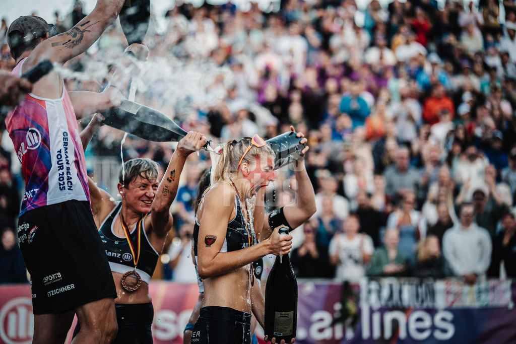 Beachvolleyball | Frauen und Männer | Deutsche Meisterschaften 2025 Timmendorfer Strand | 07.09.2025 | Nele Barber rechts bekommt von Melanie Gernert links eine Bierdusche während der Siegerehrung