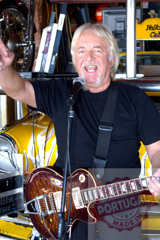 Senior musician playing electric guitar and singing with microphone | Enthusiastic senior musician playing electric guitar and singing with microphone in a garage - Realized with Pictrs.com