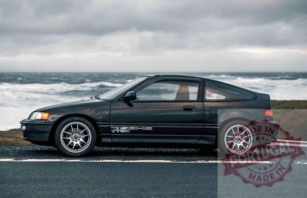 Honda CR-X parked by ocean on coastline road | Black Honda CR-X hatchback parked by a rough ocean on a cloudy day - Realized with Pictrs.com