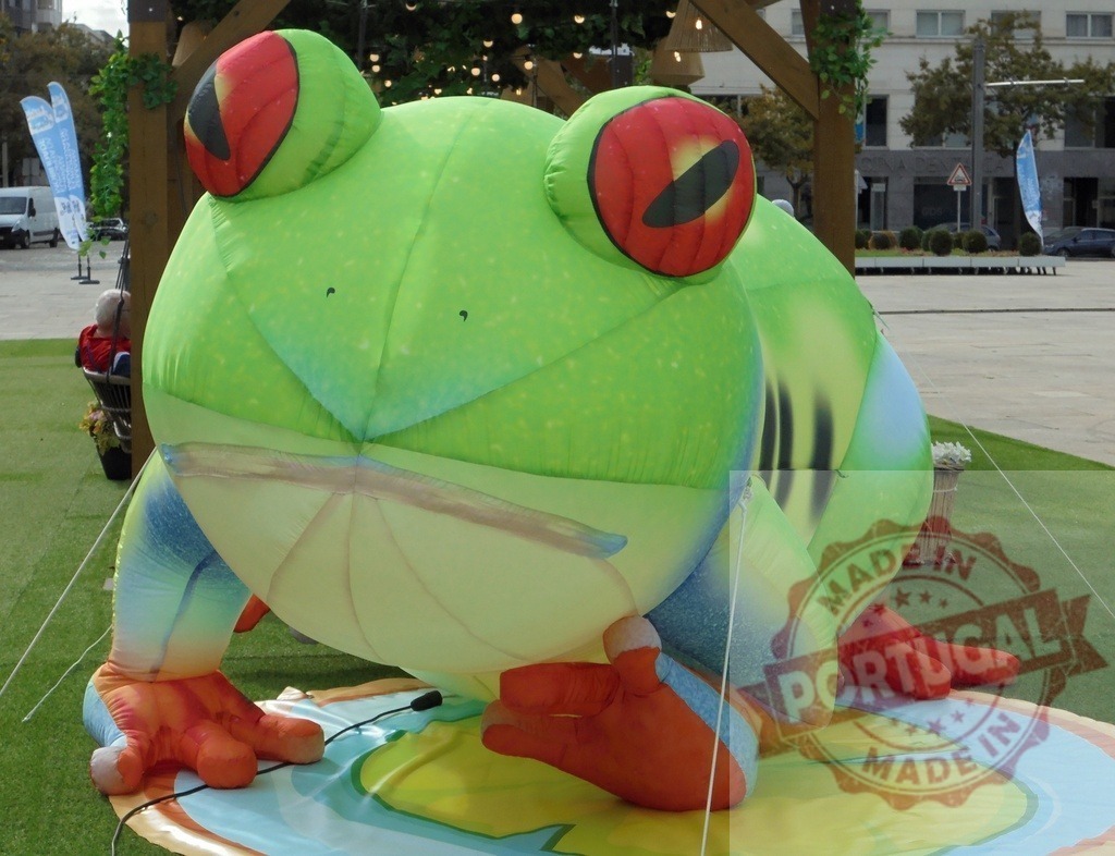 Inflatable giant red eyed tree frog public art installation | Large inflatable green frog with red eyes sitting in a public square - Realized with Pictrs.com