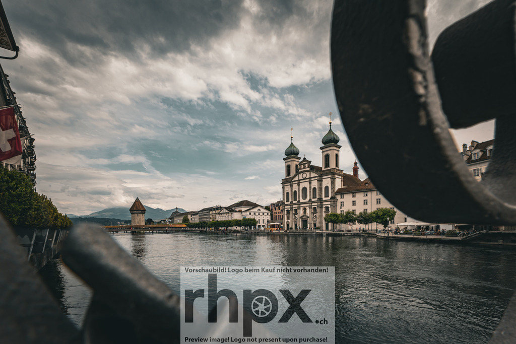 Kapellbrücke und Jesuitenkirche Luzern mit Blick über die Reuss | Barock. Fluss. Wahrzeichen.Ein einzigartiger Blickwinkel auf die prächtige Jesuitenkirche und Kapellbrücke in Luzern, eingerahmt von städtischen Elementen. Das ruhige Wasser der Reuss unterstreicht die historische Eleganz und die besondere Atmosphäre dieses Schweizer Ortes.Wähle unter "Produktauswahl" dein Wunschformat: Vom klassischen Wandbild über Puzzle &amp; Tassen bis zum digitalen Download (z.B. als Handy-Hintergrund). - Realisiert mit Pictrs.com