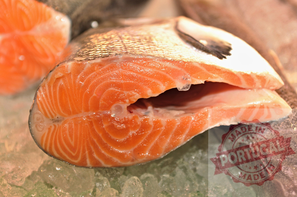 Fresh salmon fish steak on ice at market | Raw salmon steak displaying orange flesh and skin pattern on crushed ice - Realized with Pictrs.com