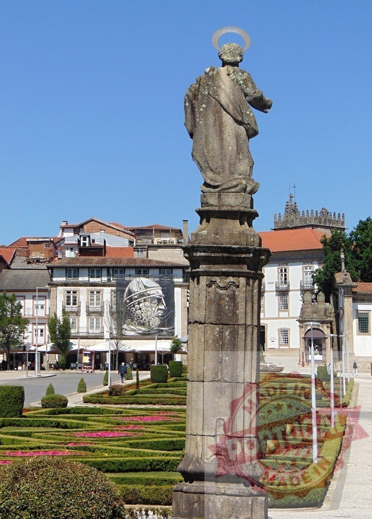 Stone saint statue watching over formal garden in Guimarães. Region Norte - Portugal | Stone saint statue with halo standing in formal garden with hedges and flowers - Realisiert mit Pictrs.com