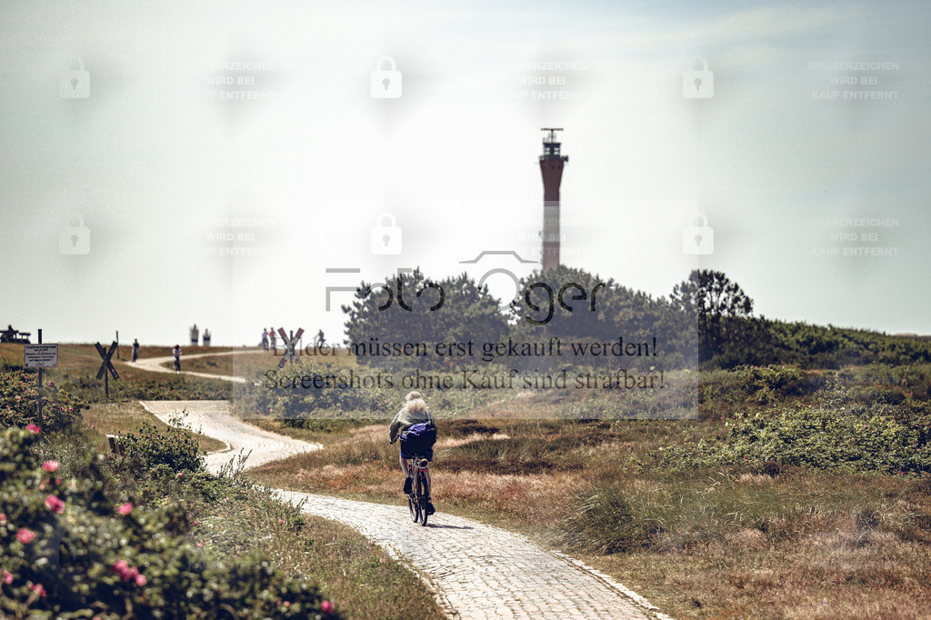 Radtour am Leuchtturm – Wangerooge | Ein Sommertag auf Wangerooge: der Weg schlängelt sich durch die Dünen, der Wind trägt den Duft des Meeres heran, und in der Ferne ragt der Leuchtturm empor.Dieses Bild fängt die Ruhe und Freiheit der Nordseeinsel ein – ein Moment zwischen Bewegung und Gelassenheit, zwischen Himmel und Meer. - Realisiert mit Pictrs.com