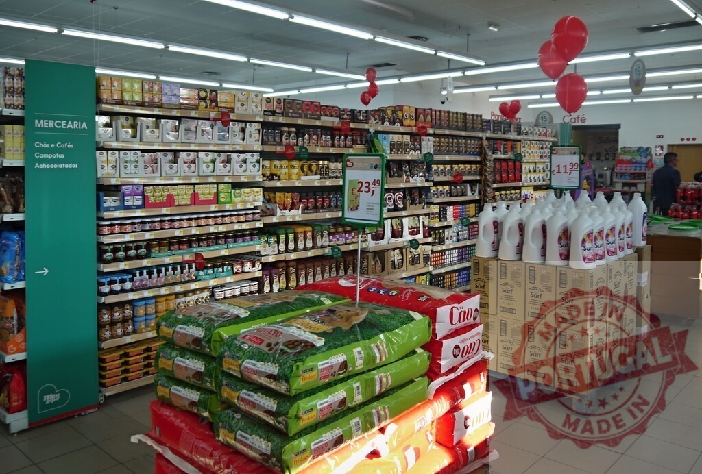 Supermarket interior showing retail shelves and promotions | Supermarket interior displaying shelves with various products, pet food, detergents, and red balloons - Realisiert mit Pictrs.com