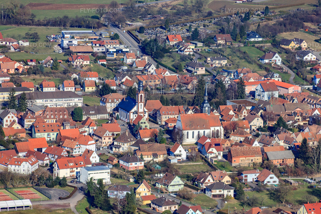 Aerial view: Rue des Écoles with two churches in Soultz-sous-Forêts in the state Bas-Rhin, France. – Photo: IMG_37449.jpg taken on 02/07/2011 by Werner Riehm/FLY-FOTO.com – Resolution of the original: 4752 x 3168 px