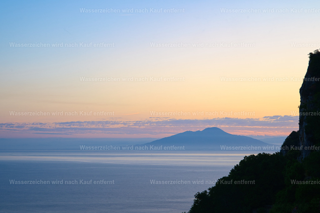 Capri - Sonnenaufgang über dem Vesuv | Capri ist eine traumhafte Insel im Golf von Neapel, bekannt für türkisblaues Meer, beeindruckende Felsklippen, mediterrane Landschaften und die berühmten Faraglioni. - Realisiert mit Pictrs.com