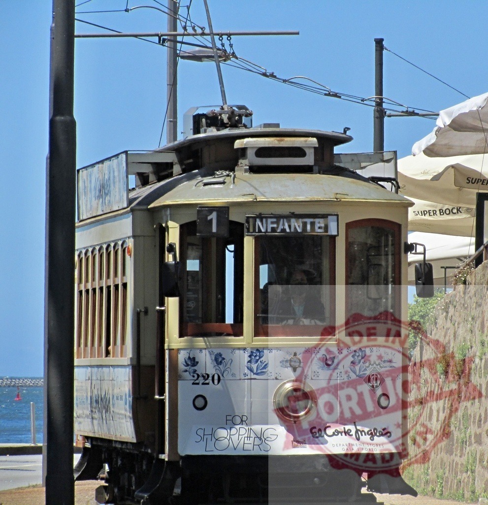 Vintage Infante tram driving along ocean in Porto, Portugal | Vintage Infante tram 220, decorated for El Corte Inglés, driving along the coastline in Porto - Realized with Pictrs.com