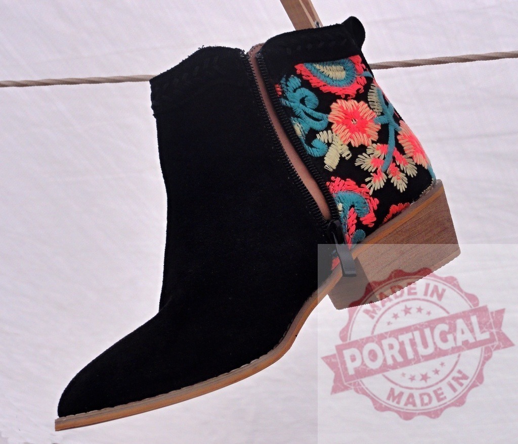 Black suede ankle boot with floral embroidery hanging | Black suede ankle boot with colorful floral embroidery and zipper hanging on a clothesline - Realized with Pictrs.com