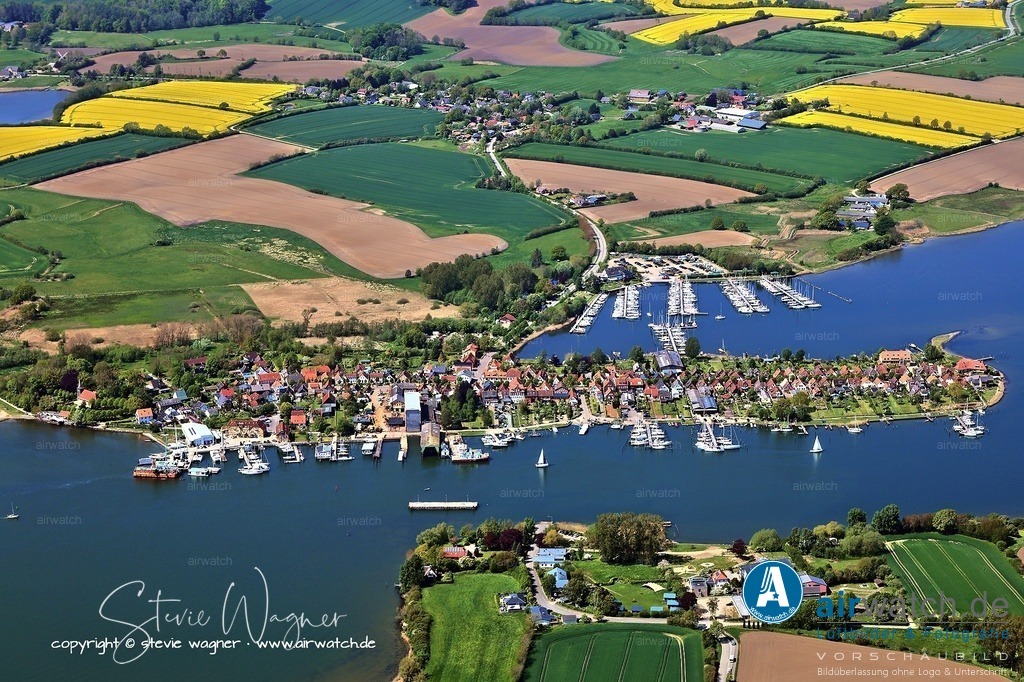 Luftbild Ostseefjord Schlei, Stadt Arnis - kleinste Stadt Deutschlands - Perle an der Schlei | Wirtschaftliche Blüte und Niedergang - Von etwa 1750 bis 1864 erlebte Arnis seine wirtschaftliche Blütezeit als Fischer- und Schiffersiedlung. Zu Hochzeiten verfügte der Ort über 88 Schiffe und hatte über 1.000 Einwohner. Die Schifffahrt nach Skandinavien war die wirtschaftliche Grundlage.