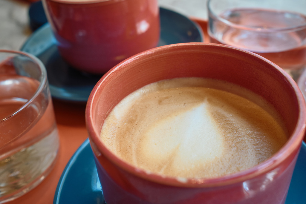 Melange in einer roten Tasse mit blauer Untertasse | Wien, Austria - June 13, 2025: Melange in einer roten Tasse mit blauer Untertasse. - Realisiert mit Pictrs.com