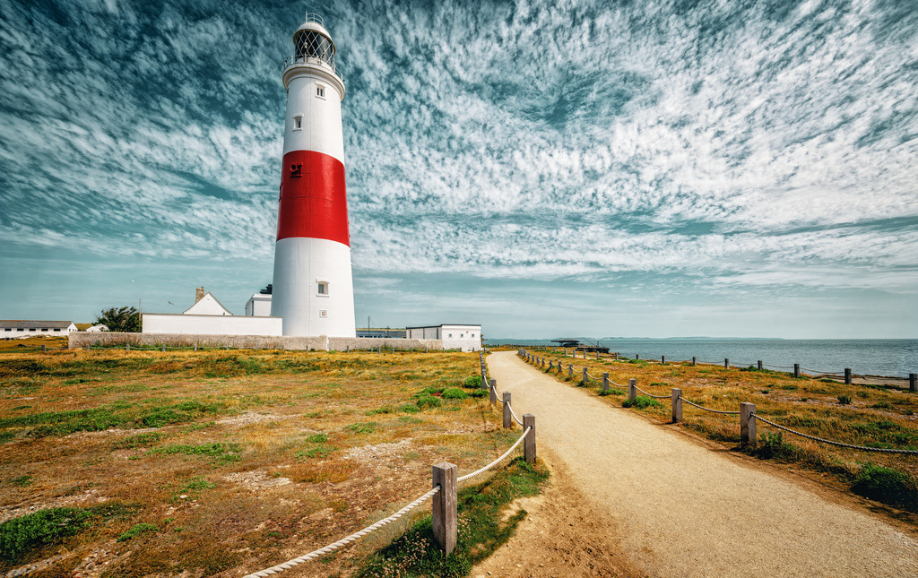 Der Leuchtturm Portland Bill Lighthouse-Portland in Dorset | Dies ist der Portland Bill Lighthouse an der Südspitze der Isle of Portland in Dorset, England.Der Turm wurde zwischen 1903 und 1905 aus Sandstein erbaut und ist 41 Meter hoch.Er ist für seine markante weiß-rote Farbgebung bekannt und wird vom Trinity House Lighthouse Service betrieben.Der Leuchtturm ist heute ein Besucherzentrum und kann besichtigt werden, wobei man auch auf die Spitze steigen kann - Realisiert mit Pictrs.com