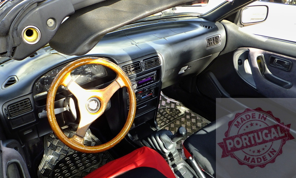Wooden steering wheel in a Nissan Sunny convertible car interior | Interior view of a tuned Nissan Sunny car showing wooden steering wheel, dashboard and seats - Realisiert mit Pictrs.com