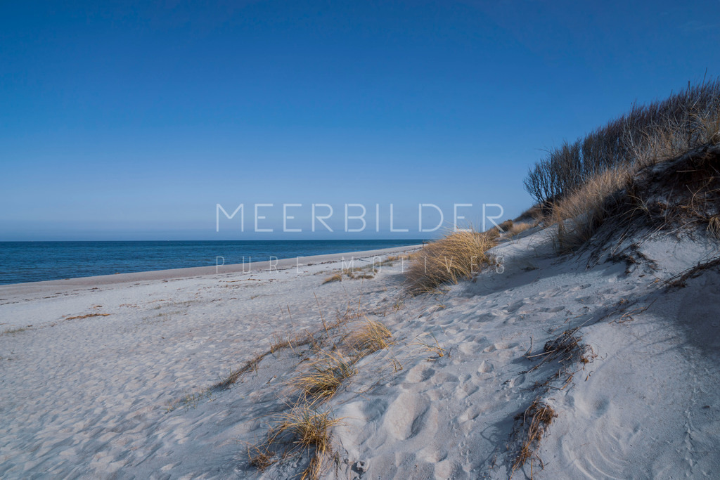 Strandbild mit Düne und blue sky | Tauchen Sie ein in die unberührte Schönheit der Natur mit unserem Ostseebild: dem "Strandbild mit Düne & Blue-Sky". Erleben Sie die Ruhe und Gelassenheit, die von diesem herrlichen Motiv ausgeht. Der feine Zuckersand, das sanfte Dünengras im Winterkleid sowie der strahlend blaue Himmel schaffen eine harmonische Szenerie, die den Betrachter verzaubert.
Ob als Blickfang im Wohnzimmer, im Büro oder als Geschenk für einen geliebten Menschen - dieses Strandbild ist auf allen unseren Druckformaten einsetzbar und passt perfekt in jedes Ambiente. Die hochwertige Druckqualität sorgt dafür, dass jedes Detail dieser Aufnahme zur Geltung kommt. Ideal für Liebhaber maritimer Motive und natürlicher Schönheit.
