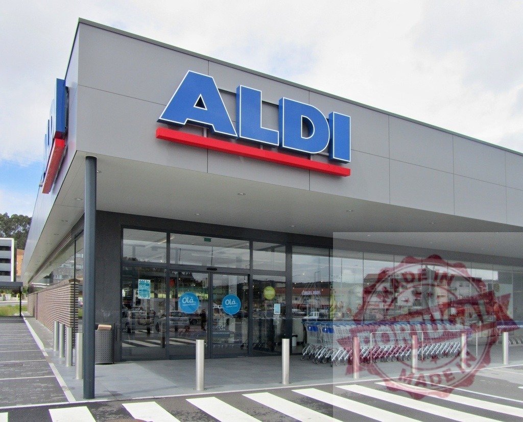 Aldi supermarket exterior with its entrance and parked shopping carts | Aldi supermarket building exterior showing entrance and shopping carts - Realisiert mit Pictrs.com