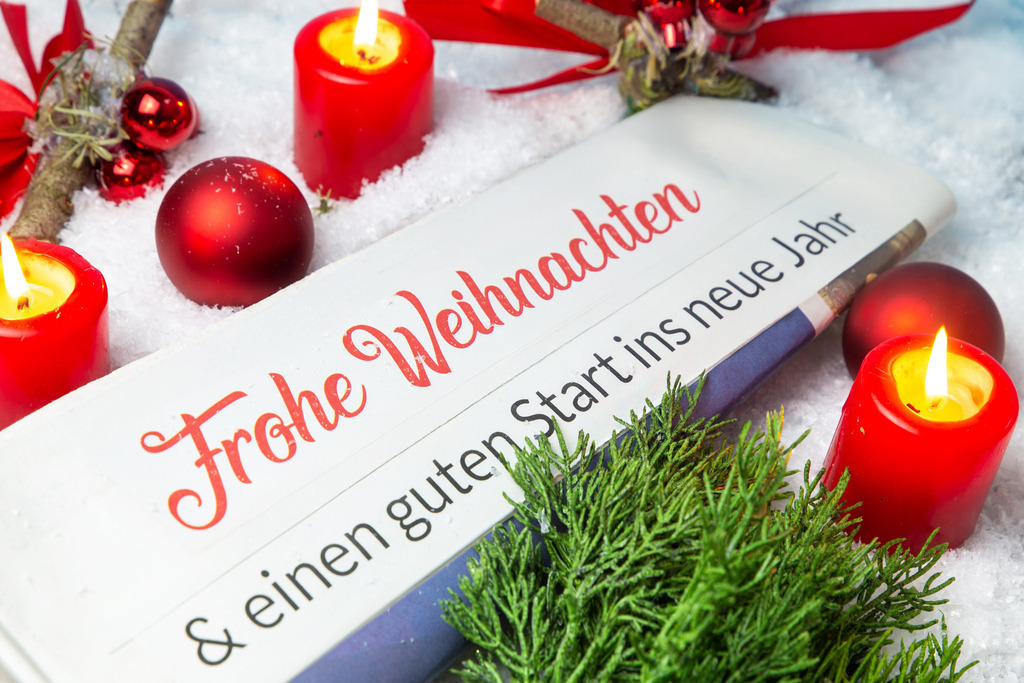 Weihnachts und Neujahrswünsche | Weihnachtsgrüße: Symbolische Zeitung mit der Headline FROHE WEIHNACHTEN & EINEN GUTEN RUTSCH INS NEUE JAHR zwischen Weihnachtsdekoration - Realisiert mit Pictrs.com