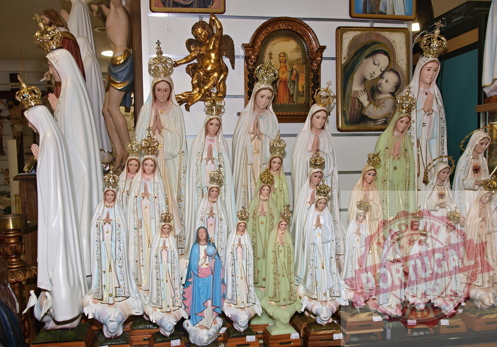 Statues of Our Lady of Fatima displayed in a shop | Several statues of Our Lady of Fatima in different sizes are displayed on shelves in a religious shop - Realized with Pictrs.com