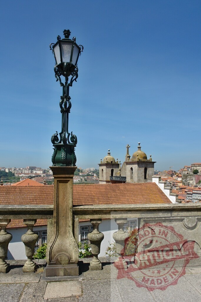 Ornamental street lamp in Porto, Portugal with cathedral. Porto - Portugal | Ornate street lamp standing on a stone balustrade with city rooftops and cathedral in background - Realized with Pictrs.com