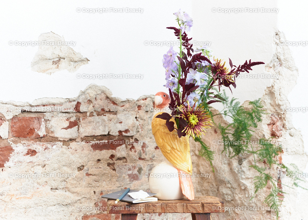 Dahlien mit Amaranth und Rittersporn vor Mauer | Strauß aus Dahlien mit Amaranth und Rittersporn vor abgebröckeltem Putz in Papageienvase, wunderschönes Motiv als Kunstdruck auf Leinwand oder Holz. - Realisiert mit Pictrs.com