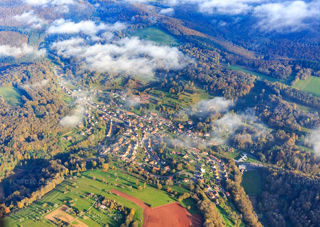 Aerial view: Village view from the northwest under clouds in Schorbach in the state Moselle, France. – Photo: IMG_143770.jpg taken on 10/26/2024 by Werner Riehm/FLY-FOTO.com – Resolution of the original: 5133 x 3648 px