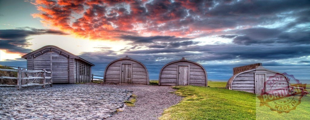 Lindisfarne fisherman huts at sunset on Holy Island | Historic fishing boat sheds on a grassy coast under a dramatic sunset sky - Realized with Pictrs.com