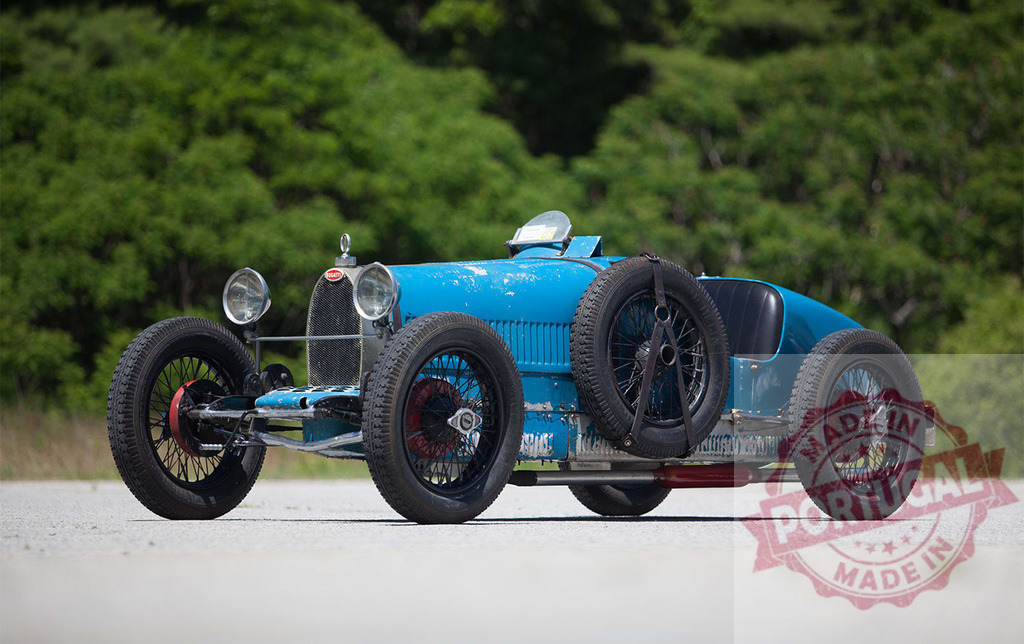 Bugatti Type 35 vintage race car outdoors | Bugatti Type 35 classic car standing outdoors on a paved surface with green trees - Realized with Pictrs.com