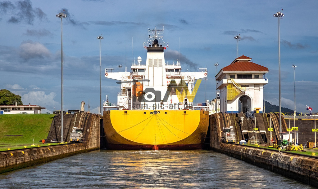 Ein gelbes Schiff fährt in den Panamakanal-Schleuse-Mittelamerika | Ein gelbes Schiff wird in den Panamakanal eingeschleust. An den Kaimauern ist sehr wenig Platz - Realisiert mit Pictrs.com