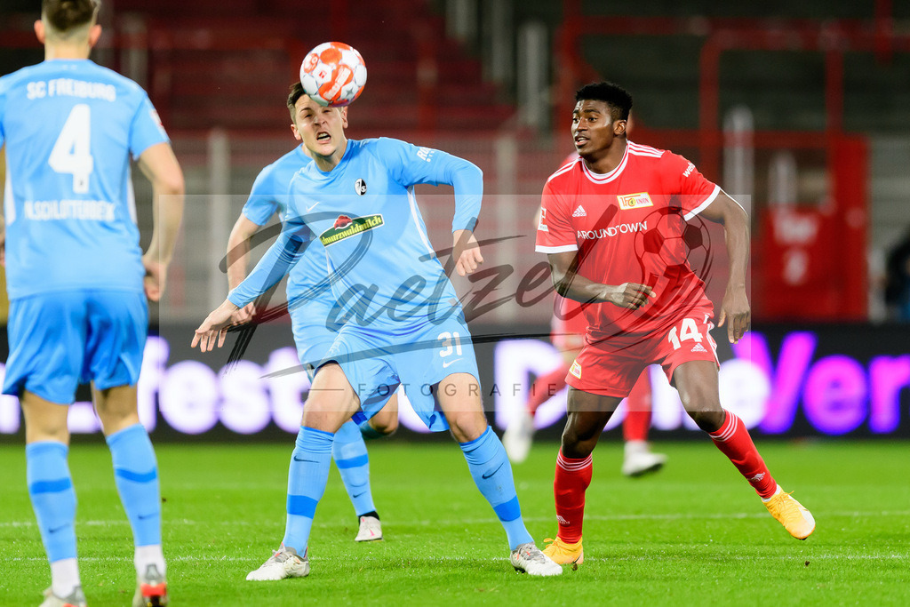 FCUFRE20211215_010 | Fussball, Herren: Keven Schlotterbeck (SC Freiburg) und Taiwo Awoniyi (1. FC Union Berlin) im Zweikampf bei dem Spiel der 1. Bundesliga zwischen 1. FC Union Berlin und SC Freiburg im Stadion An der Alten Foersterei am 15.12.2021 in Berlin, Deutschland.DFB / DFL REGULATIONS PROHIBIT ANY USE OF PHOTOGRAPHS AS IMAGE SEQUENCES AND/OR QUASI-VIDEO. - Realisiert mit Pictrs.com