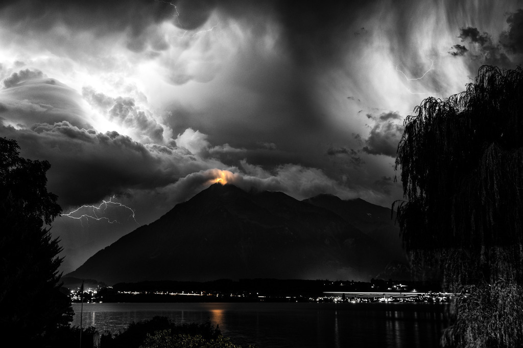 Niesenlicht | Gewitter über dem Niesen mi fantastischen, durch die Blitze angeleuchteten Wolkenbildern. Als Selektivfarbe habe ich in dieser Schwarzweiss-Anwendung das Niesenlicht und dessen Spiegelung im Thunersee restauriert. 
-----------------------------------------------
Thunderstorm over the Niesen with fantastic cloud images illuminated by the lightning. In this black and white application, I restored the Niesen top light and its reflection in Lake Thun as a selective color.
-----------------------------------------------
Dieser Druck ist in einer limitierten Auflage von 5 Exemplaren erhältlich. 
This print is available in a limited edition of 5 copies. 
http://art.hess.photography/53-niesenlicht.html - Realisiert mit Pictrs.com