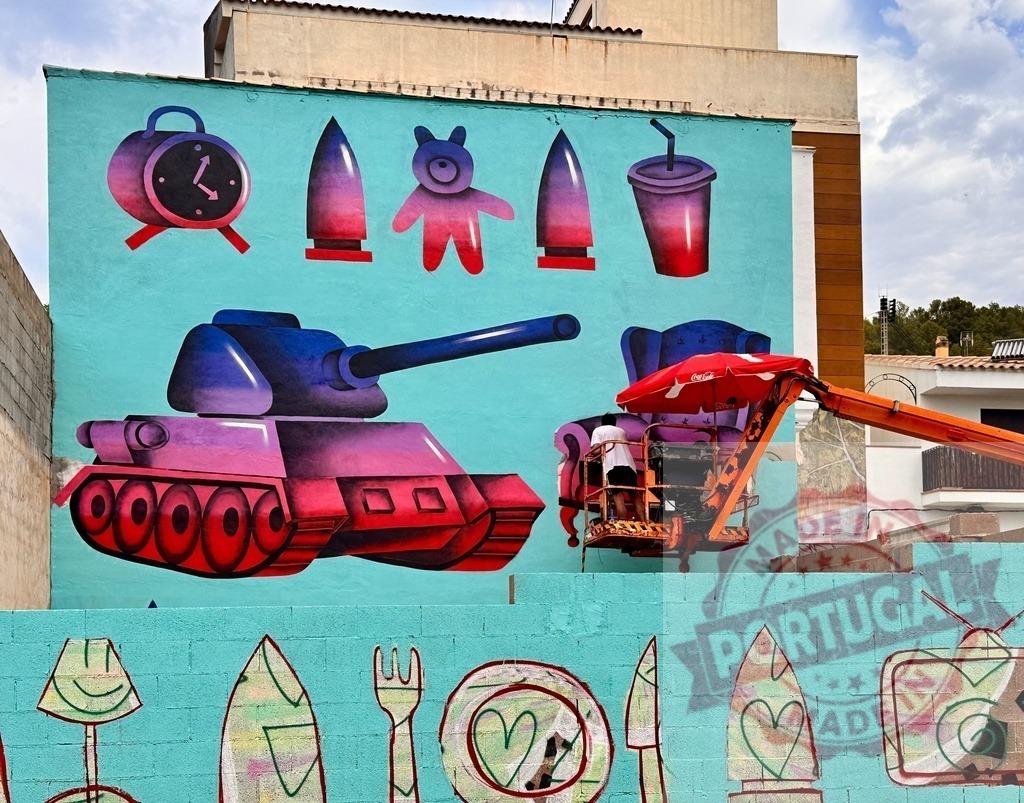 Artist painting tank and consumer icons street art mural | Artist on a cherry picker painting a vibrant street art mural depicting a tank and consumer icons - Realized with Pictrs.com