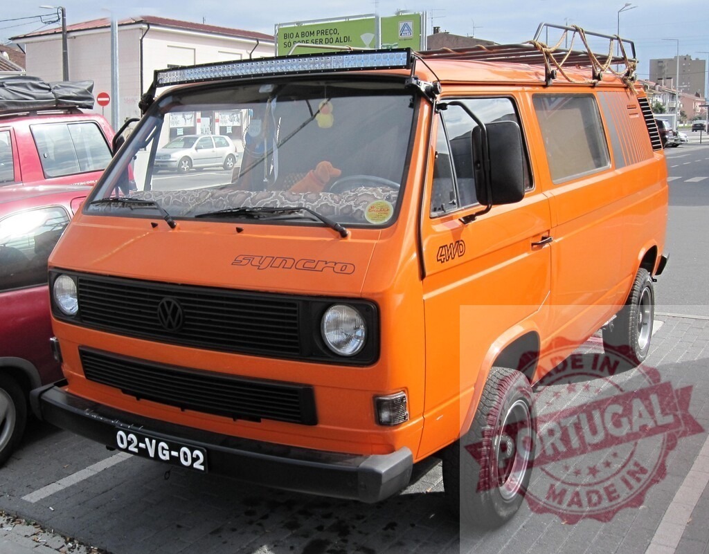 Orange Volkswagen Syncro T3 van parked on street | Orange customized Volkswagen T3 Syncro van parked outdoors, ready for travel and adventure - Realisiert mit Pictrs.com