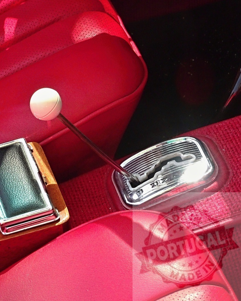 Vintage car interior featuring red leather and chrome gear shifter | Classic automobile interior with luxurious red leather seats and a prominent gear selector - Realized with Pictrs.com