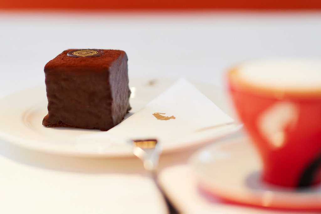 Cafe Meinl | Wien, Austria - August 28, 2017: Cafe Meinl am Graben, Schokowürfel mit Melange in roter Tasse. - Realisiert mit Pictrs.com