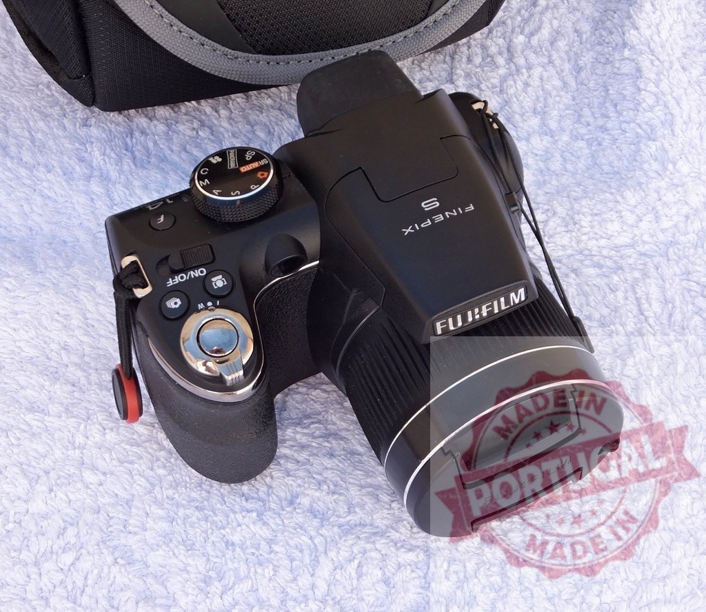 Fujifilm FinePix digital bridge camera on white towel | Fujifilm FinePix S digital camera lying on a white terry towel - Realized with Pictrs.com