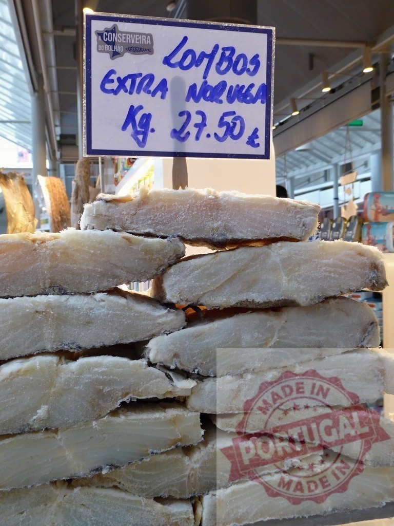 Bacalhau loins extra Noruega for sale | Dried salted cod fish, a traditional Portuguese ingredient, stacked at Mercado do Bolhão - Realized with Pictrs.com