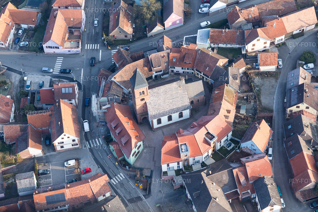 Aerial view: Lutheran-Protestant fortified church in the village center, surrounded by a ring of houses in Dossenheim-sur-Zinsel in the state Bas-Rhin, France.Photo: IMG_105330.jpg taken on 03/25/2018 by Werner Riehm/FLY-FOTO.comResolution of the original: 5472 x 3648 px