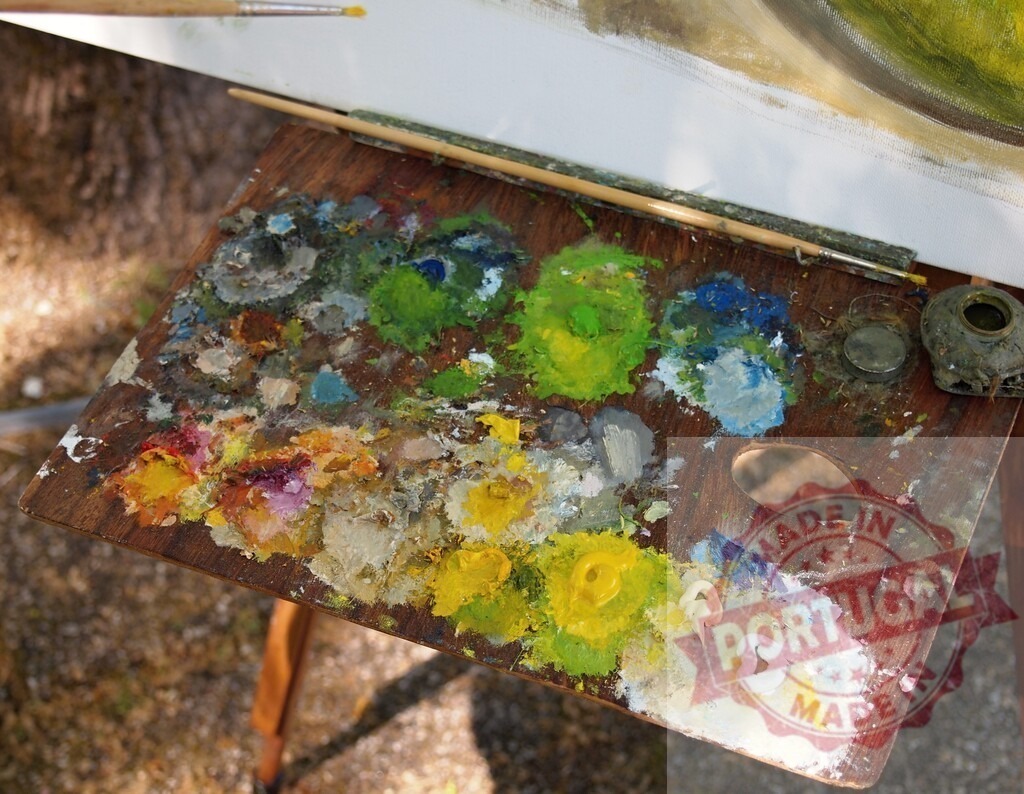 Artist wooden palette with colorful oil paints and brushes | Wooden palette displaying vibrant oil paints and brushes during outdoor art creation - Realized with Pictrs.com