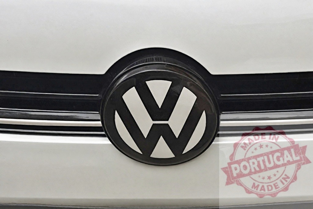 Volkswagen car brand logo on white grill | Close up view of the black and white Volkswagen emblem on a vehicle - Realisiert mit Pictrs.com