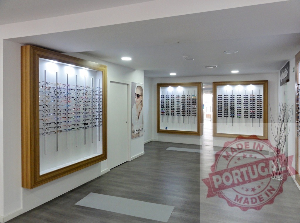Eyewear store interior displaying eyeglasses and sunglasses | Optician shop interior with various eyeglasses and sunglasses on modern wall displays - Realized with Pictrs.com