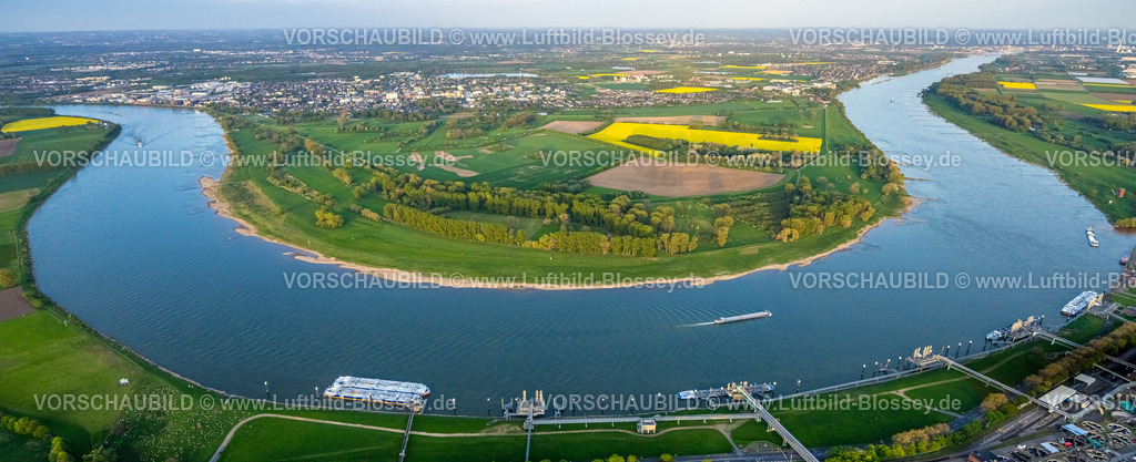Monheim240404021 | Luftbild, Fluss Rhein Rheinbogen mit Rheinufer und grünen Bäumen, Blick auf Monheim mit Wiesen und Feldern, gelbes Rapsfeld, Ausflugsschiffe an der Anlegestelle, Binnenschifffahrt, Monheim am Rhein, Rheinland, Nordrhein-Westfalen, Deutschland