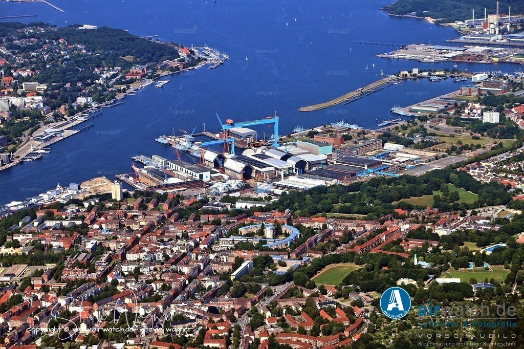 Luftbild Kiel Hafen - Weg zum Welthafen - Reichskriegshafen | Weg zum Welthafen (19. Jahrhundert) - Reichskriegshafen: 1871 wurde Kiel zum Haupthafen der kaiserlichen Marine ernannt. Dies löste ein enormes Bevölkerungswachstum und den Ausbau massiver Werftanlagen (wie der Germaniawerft und den Howaldtswerken) aus.