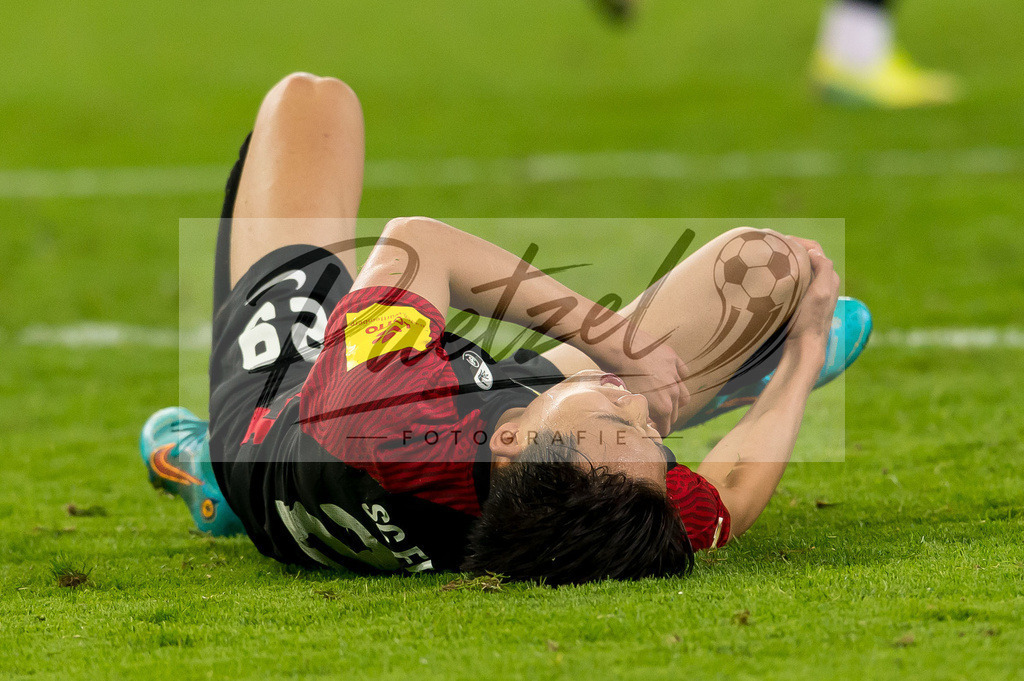 HSVSCF20220419_138 | Fussball, Herren: Woo-yeong Jeong (SC Freiburg) verletzt am Boden beim DFB-Pokal-Halbfinalspiel zwischen Hamburger SV und SC Freiburg im Volksparkstadion am 19.04.2022 in Hamburg, Deutschland.DFB / DFL REGULATIONS PROHIBIT ANY USE OF PHOTOGRAPHS AS IMAGE SEQUENCES AND/OR QUASI-VIDEO. - Realisiert mit Pictrs.com